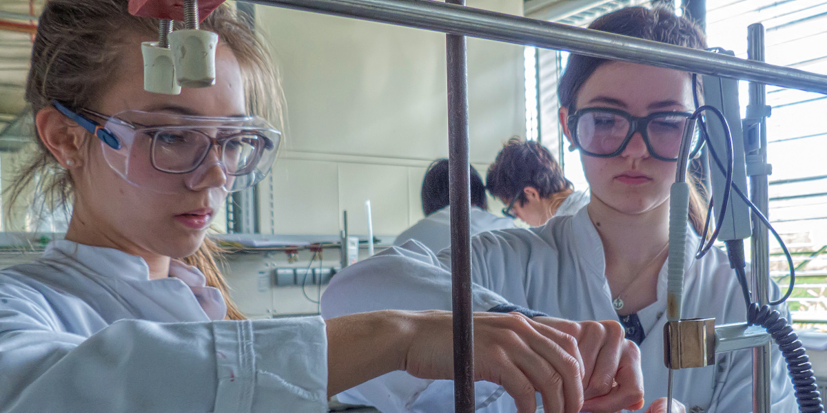 Zwei junge Frauen arbeiten mit Schutzkleidung im Chemie-Labor